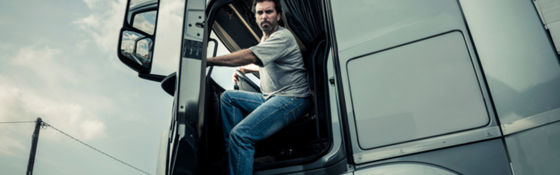 Truck driver getting out of semi truck cab