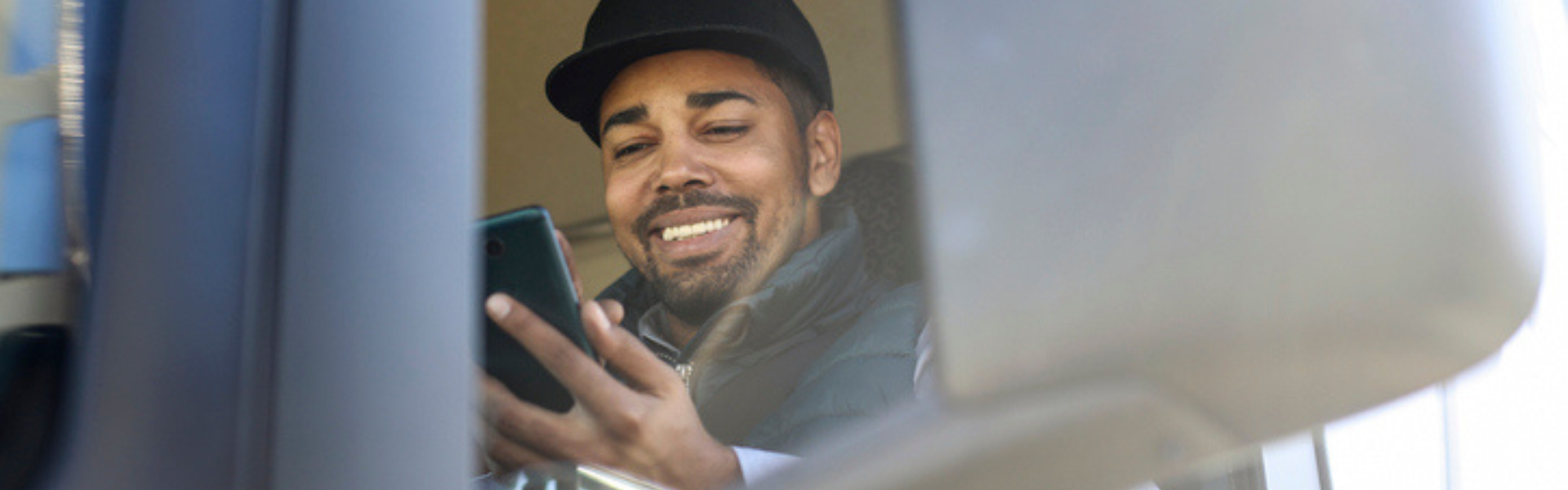 Trucker in semi truck cab using smart phone app