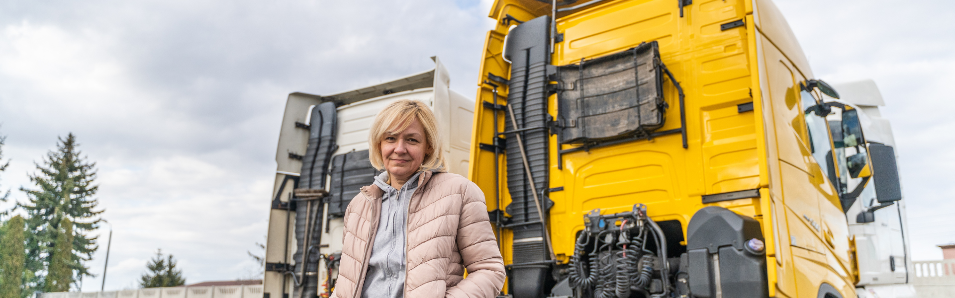 Woman standing by yellow semi truck
