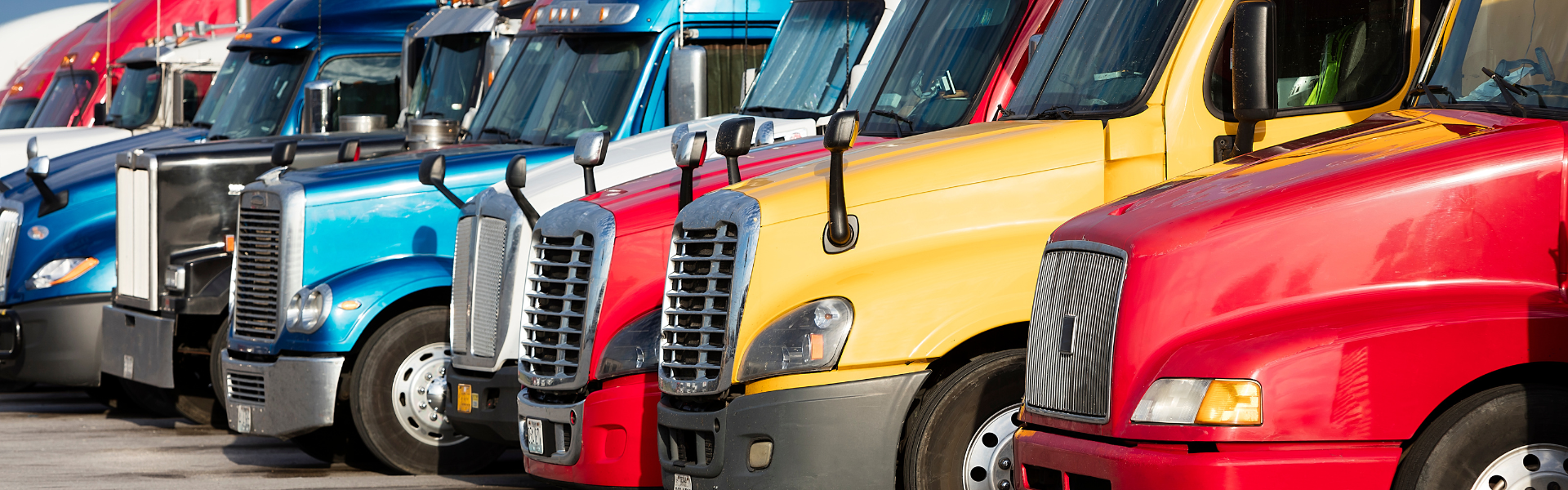several different kinds of semi trucks parked in a row