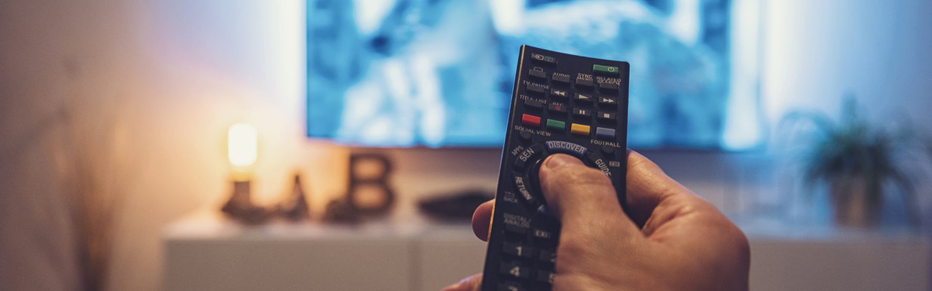 man holding remote with tv in background