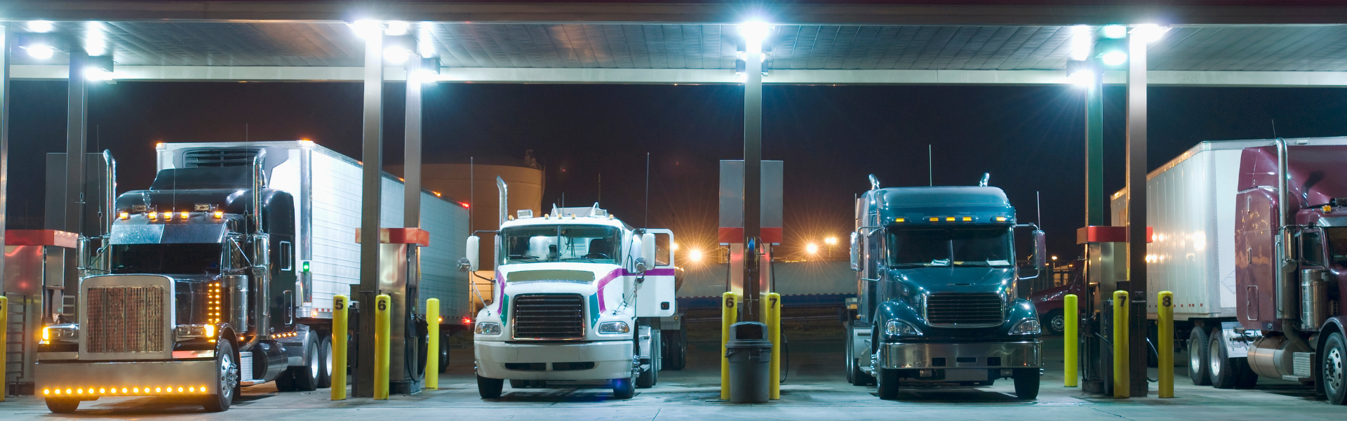 semi trucks parked under canopy at fuel island truck stop