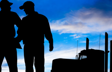 silhouette of men and semi truck