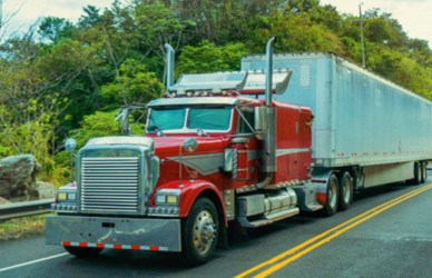semi truck on mountain road with cars behind