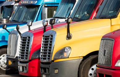 several different kinds of semi trucks parked in a row