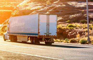 semi truck on curvy mountain road at sunrise