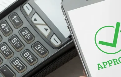 payment processed on mobile phone displaying green "approved" message with checkmark