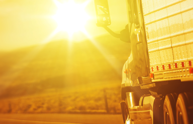 semi truck driving towards sunrise