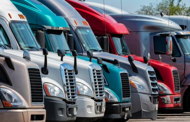 line of parked semi trucks of varying kind and color