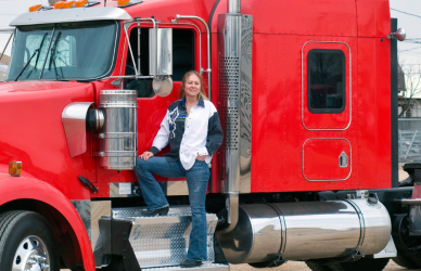 woman standing in door of red semi truck