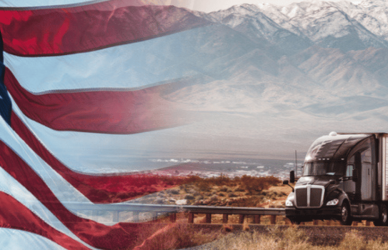 semi truck with american flag and mountains in the background