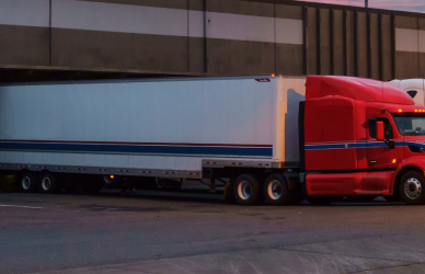 semi trucks backed up to the loading dock at dusk
