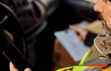 trucker looking at phone in truck