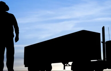silhouettes of two men and a semi truck