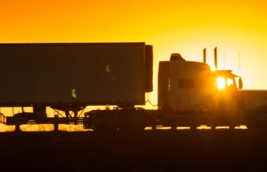 semi truck silhouetted in a sunset