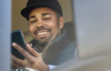 Trucker in semi truck cab using smart phone app