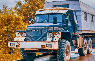 Vintage truck with patches on the cab and a living compartment in the back